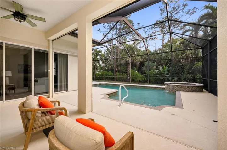 View of pool featuring a covered lanai, saltwater heated pool and spa, pool bath and screened enclosure
