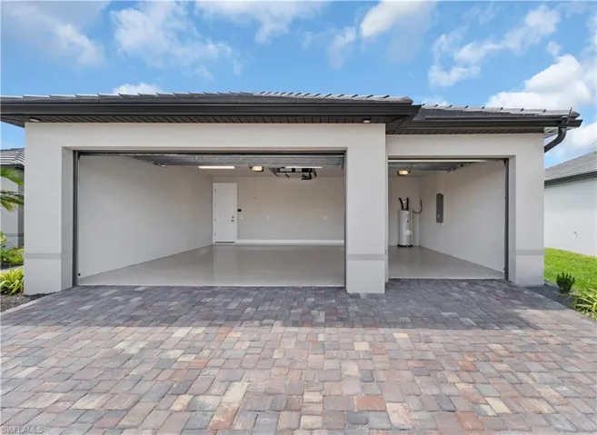Garage featuring driveway and electric water heater