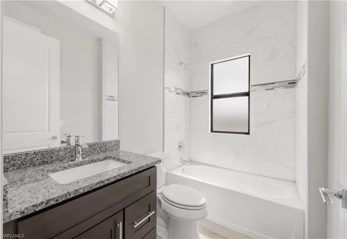 Bathroom featuring toilet, vanity, and shower / bathing tub combination