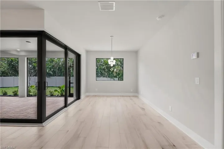 Unfurnished dining area with light wood-type flooring, visible vents, and baseboards