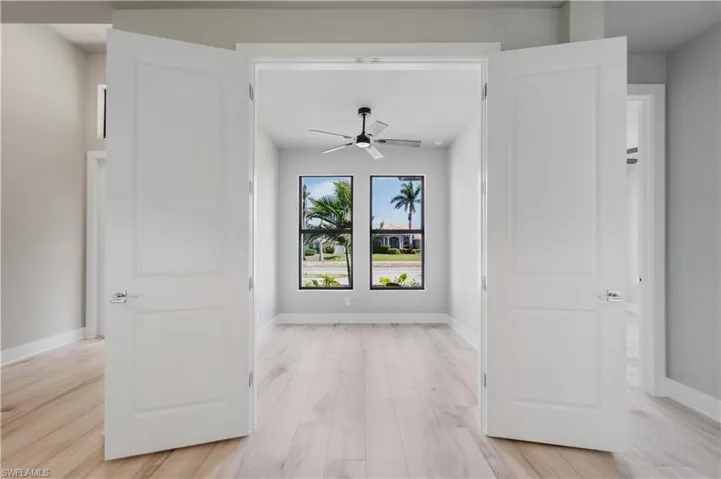 Hallway with light wood-style floors and baseboards