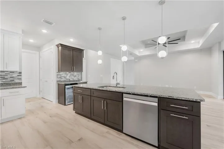 Kitchen featuring a sink, visible vents, stainless steel dishwasher, and backsplash