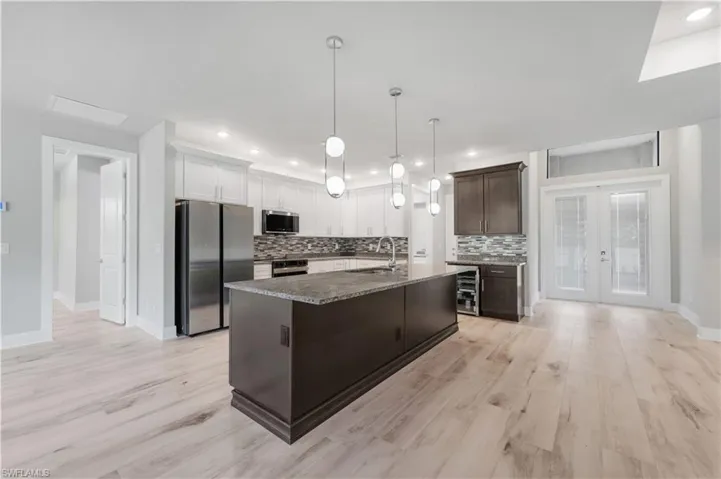 Kitchen with tasteful backsplash, a center island with sink, a sink, and stainless steel appliances