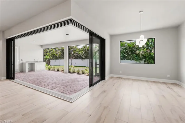 Unfurnished living room with a healthy amount of sunlight, wood finished floors, and baseboards