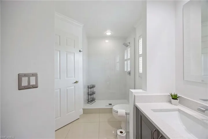 Bathroom with vanity, light tile floors, and a shower stall