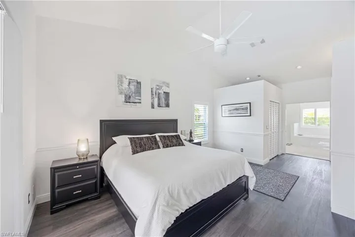 Bedroom featuring dark wood-style floors, multiple windows, ceiling fan, high vaulted ceiling, and recessed lighting