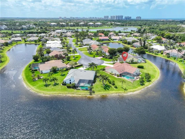 Aerial perspective of suburban area with a nearby body of water and city skyline