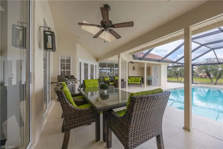 Outside lanai with ceiling fan, a patio area, vaulted ceiling, french doors, and outdoor dining space