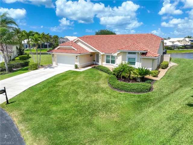 Beautiful home featuring a front yard, stucco siding, concrete driveway, a tiled roof, and a garage