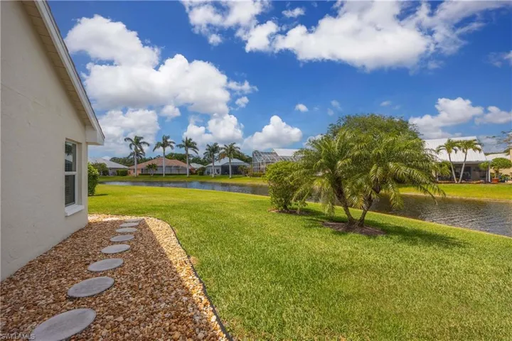 View of green side lawn featuring a water view