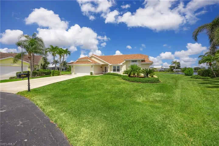Enchanting home featuring a tile roof, concrete driveway, a front lawn, and a garage