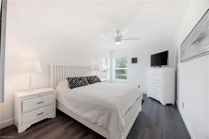Bedroom featuring dark wood-type flooring, ceiling fan, and crown molding
