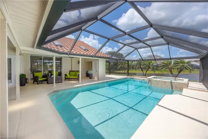 View of pool with a patio, a sunroom, outdoor lounge area, a pool with connected hot tub, and glass enclosure
