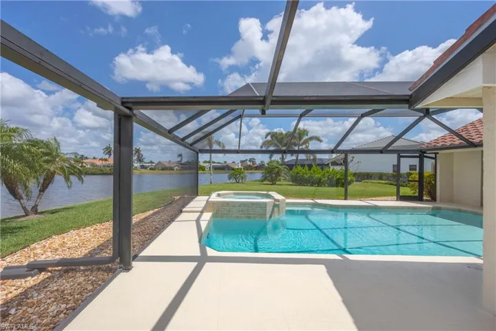 View of swimming pool with a patio, a sunroom, a pool with connected hot tub and a water view