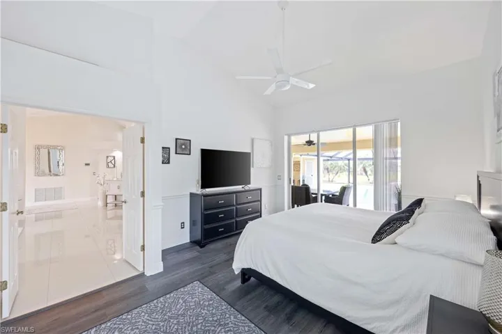 Bedroom featuring high vaulted ceiling, access to outside, dark wood finished floors, and ceiling fan