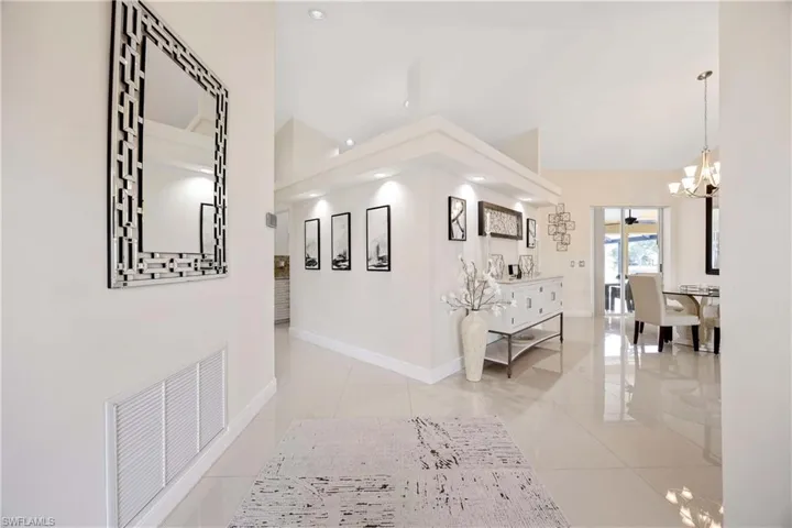 Hallway with a chandelier, light tile patterned floors, and recessed lighting