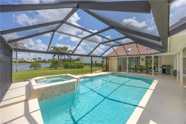 View of swimming pool featuring a patio area, a sunroom, and a yard, a grill