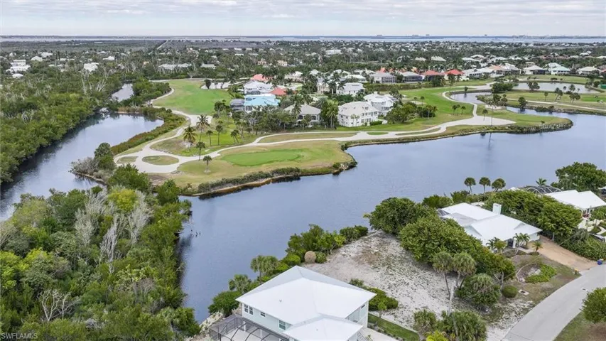 Aerial perspective of suburban area with a golf club and a large body of water