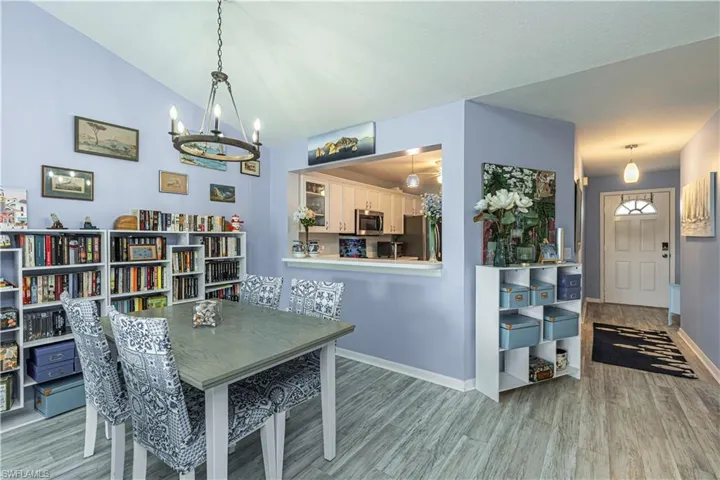 Dining space with light wood-style flooring, lofted ceiling, and a chandelier