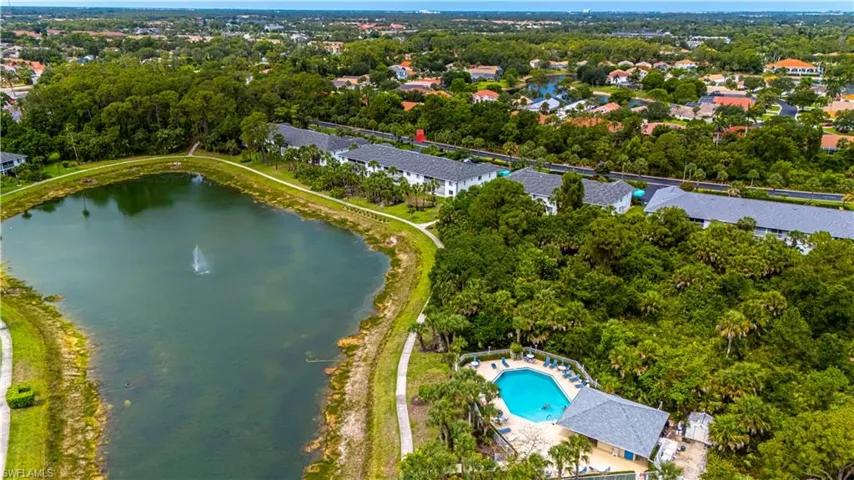 Aerial view of property and surrounding area featuring a large body of water and nearby suburban area