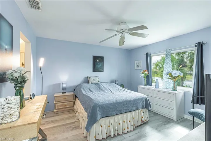 Bedroom featuring wood finished floors, ceiling fan, and an office area