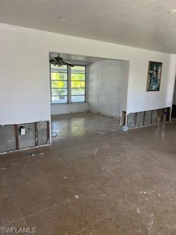 Unfurnished room featuring ceiling fan and a textured ceiling