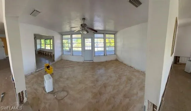 Unfurnished living room featuring ceiling fan and a healthy amount of sunlight