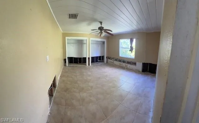 Empty room with ceiling fan and wooden ceiling