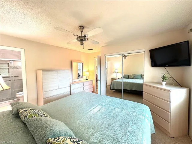 Primary Bedroom featuring connected bathroom and ceiling fan - all furniture included