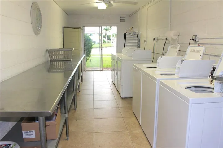 Common laundry area with ceiling fan and table to fold clothes. Laundry room for each court.