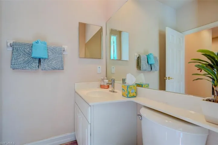 Pool Bathroom with cabinets and toilet