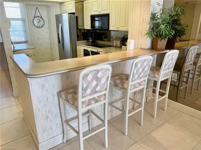 Kitchen with a breakfast bar, kitchen peninsula, and black appliances