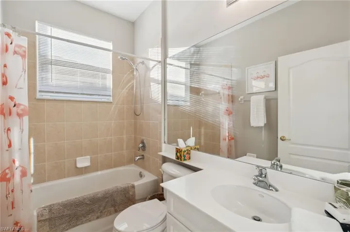 Full bathroom with vanity, and very clean tile shower / tub combo. Nice natural lighting.