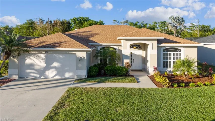 Ranch-style home featuring a front lawn and a garage