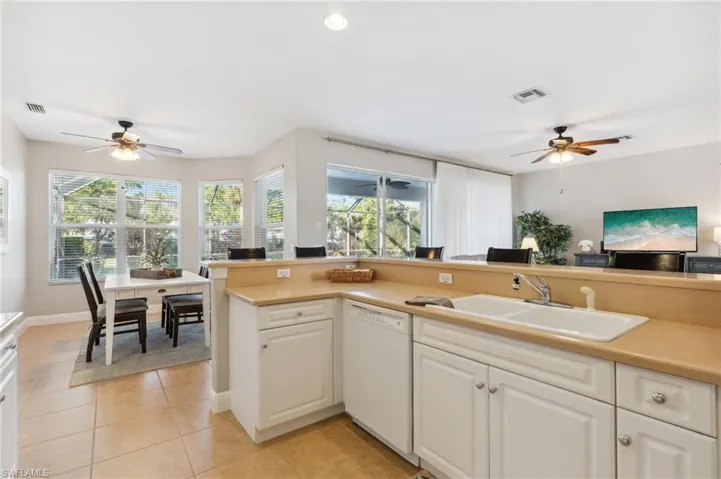 Kitchen with dishwasher, Corian counter tops and light tile flooring.