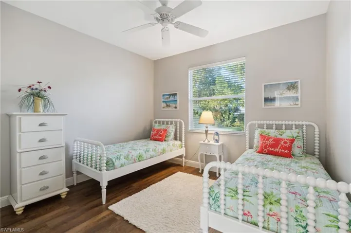 Bedroom with ceiling fan and dark wood-style flooring