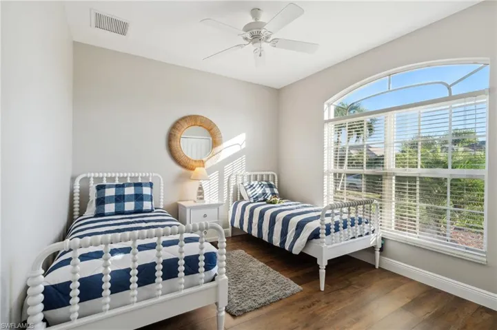 4th Bedroom featuring dark wood-like flooring, ceiling fan and big bay window.