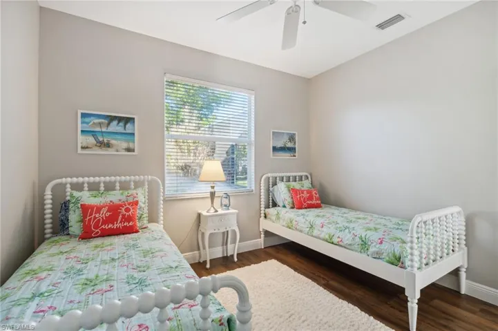 Bedroom with ceiling fan and dark wood-like flooring