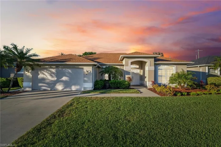 Ranch-style home featuring a nice yard and a 2 car garage.