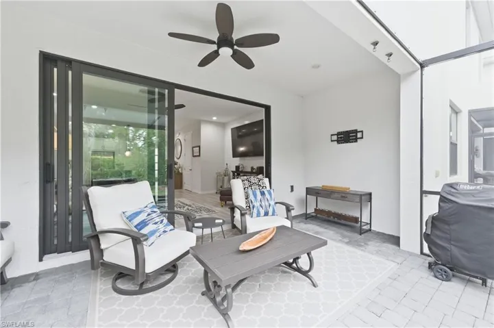 View of patio featuring ceiling fan and a lanai