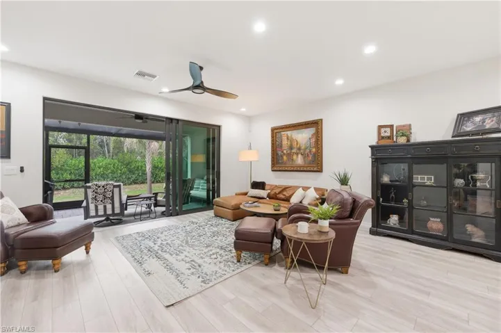 Living room featuring a ceiling fan, light wood-style flooring, and recessed lighting