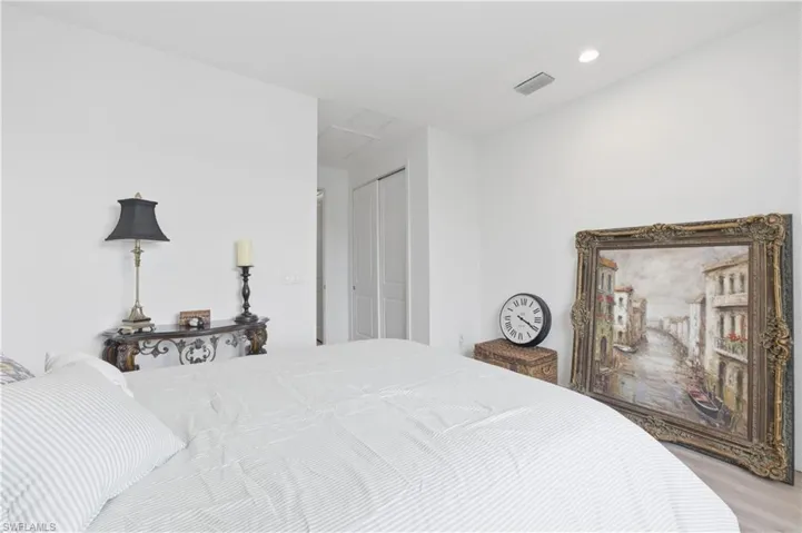 Bedroom with a closet, wood finished floors, and recessed lighting