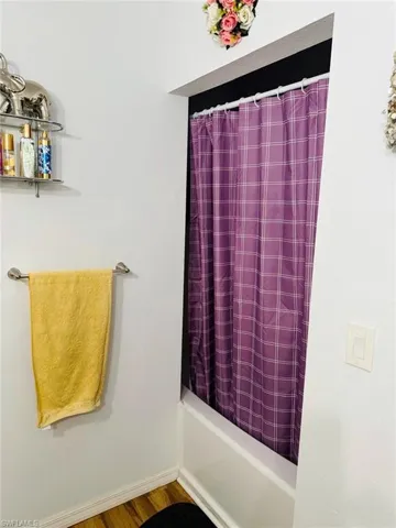 Full bathroom featuring shower / tub combo and wood finished floors