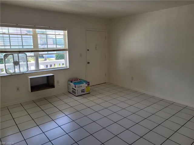 Tiled spare room featuring a wealth of natural light