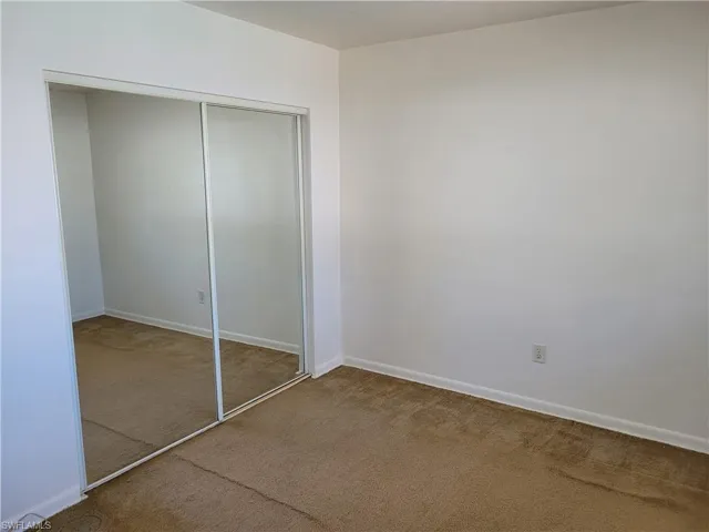 Unfurnished bedroom with carpet and a closet