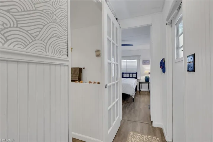 Corridor featuring wood finished floors and healthy amount of natural light