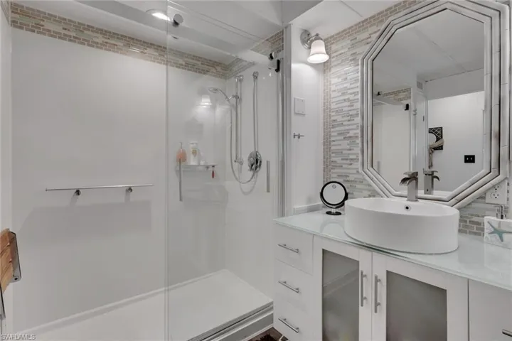 Bathroom with vanity, tasteful backsplash, and a stall shower