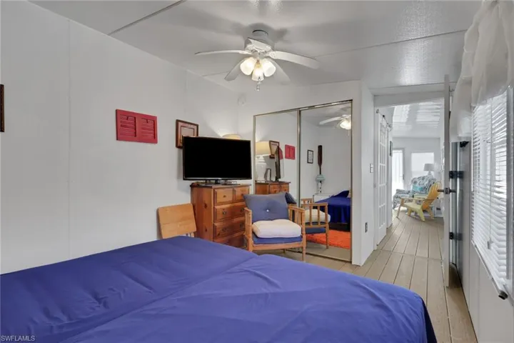 Bedroom featuring hardwood / wood-style flooring, a ceiling fan, and a closet