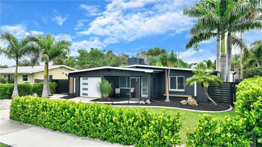 Contemporary exterior with dark siding, white-paneled garage door, and a screened entry