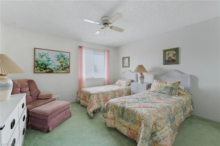 Bedroom featuring a textured ceiling, carpet flooring, and a ceiling fan